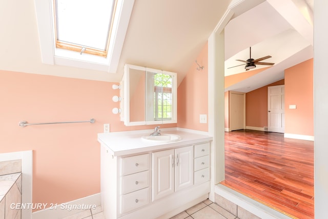 3320 N Sturgeon Rd, Midland, MI 48642 - bathroom featuring vaulted ceiling, a skylight, vanity, a ceiling fan, and wood finished floors