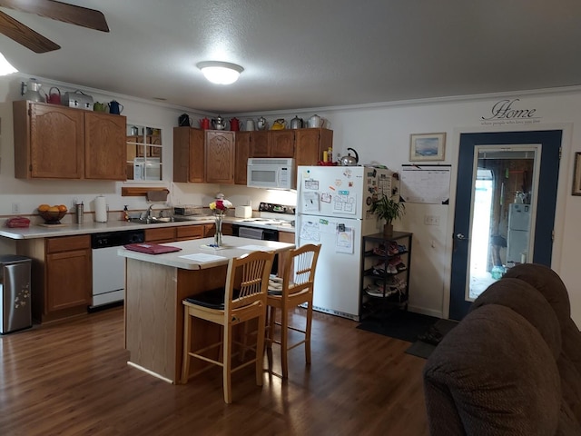 1946 Catherine Ave, Muskegon, MI 49442 - kitchen with white appliances, a sink, light countertops, dark wood-type flooring, and ornamental molding