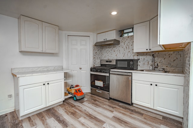 32904 Surow Dr, Warren, MI 48093 - kitchen with appliances with stainless steel finishes, a sink, under cabinet range hood, white cabinets, and tasteful backsplash
