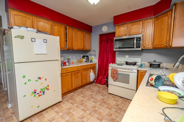 32904 Surow Dr, Warren, MI 48093 - kitchen with white appliances, light countertops, and brown cabinetry