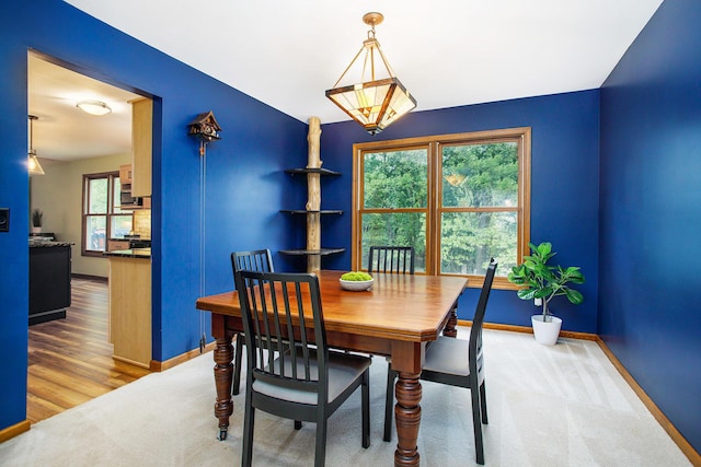 carpeted dining area featuring baseboards