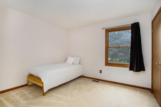 bedroom featuring light carpet and baseboards