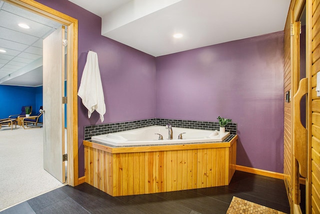 bathroom featuring a garden tub, baseboards, and recessed lighting