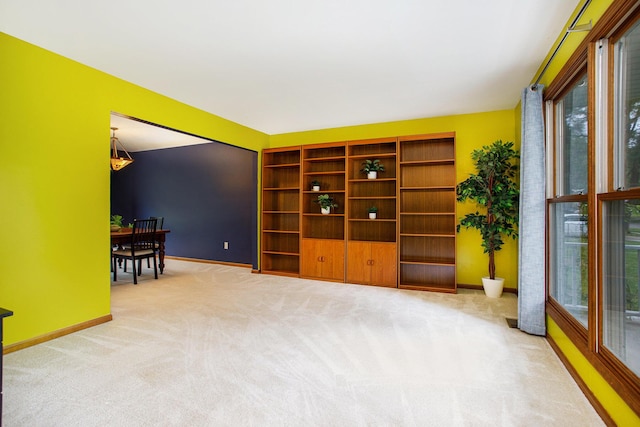 living area featuring carpet flooring and baseboards