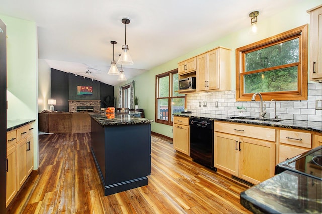 kitchen with black appliances, light brown cabinetry, a sink, a fireplace, and backsplash