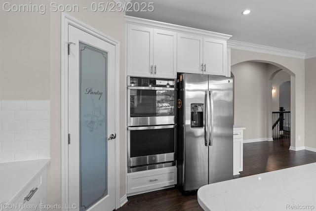 14153 Jode Park, Utica, MI 48315 - kitchen featuring appliances with stainless steel finishes, arched walkways, white cabinets, dark wood-style flooring, and ornamental molding