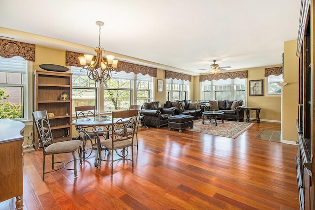 dining room featuring wood finished floors, ceiling fan, and a chandelier