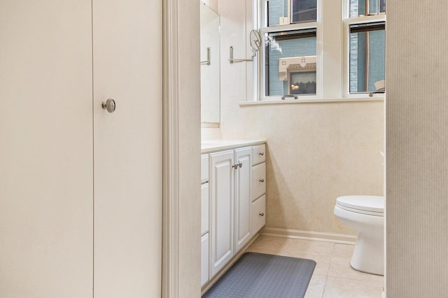 bathroom with toilet, tile patterned floors, vanity, and baseboards