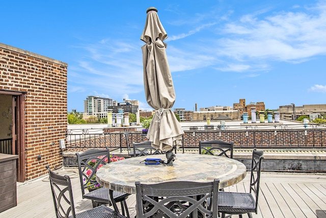 wooden terrace with outdoor dining space and a view of city