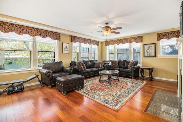living area with wood finished floors, ceiling fan, and baseboards