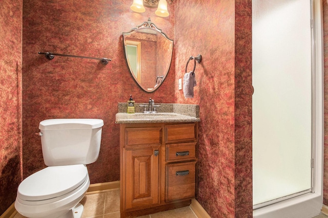 bathroom with toilet, baseboards, vanity, and tile patterned floors
