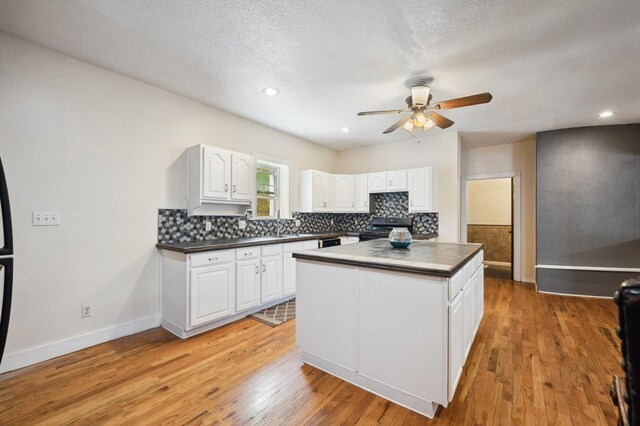 113 W Chicago St, Buchanan, MI 49107 - kitchen featuring range with gas stovetop, dark countertops, ceiling fan, white cabinets, and a textured ceiling