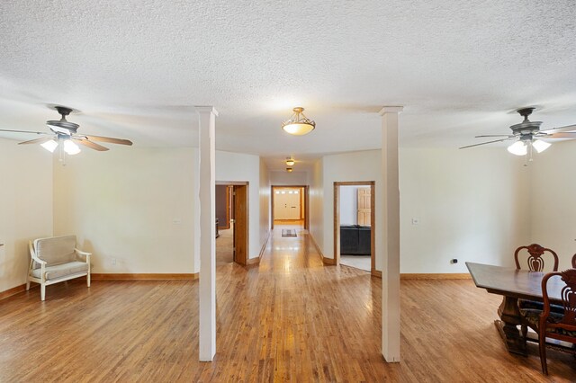 113 W Chicago St, Buchanan, MI 49107 - living room featuring a ceiling fan, light wood finished floors, decorative columns, and a textured ceiling