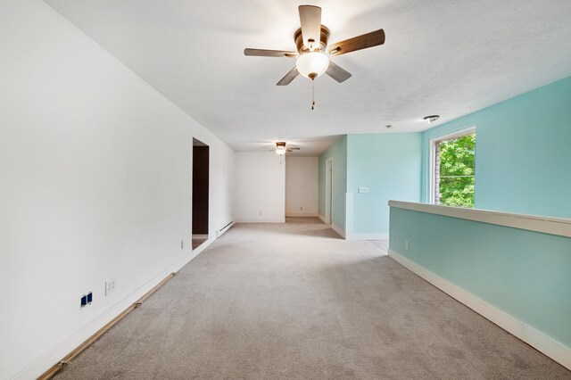 113 W Chicago St, Buchanan, MI 49107 - spare room featuring a ceiling fan, baseboards, light colored carpet, and baseboard heating