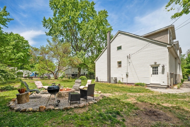 113 W Chicago St, Buchanan, MI 49107 - rear view of house featuring an outdoor fire pit, a lawn, central air condition unit, and a chimney