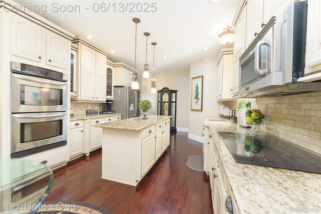 17351 Timber Crk, Holly, MI 48442 - kitchen featuring appliances with stainless steel finishes, a sink, baseboards, a center island, and tasteful backsplash