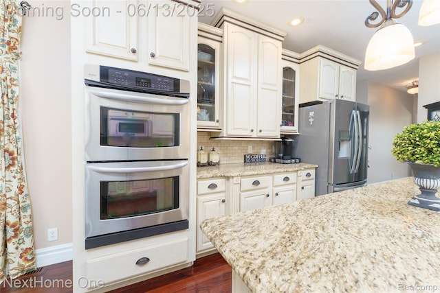 17351 Timber Crk, Holly, MI 48442 - kitchen featuring stainless steel appliances, glass insert cabinets, decorative backsplash, light stone counters, and dark wood-type flooring