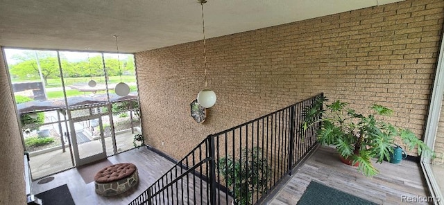995 N Cass Lake Rd Unit 233, Waterford, MI 48328 - staircase featuring wood finished floors, brick wall, and a wall of windows