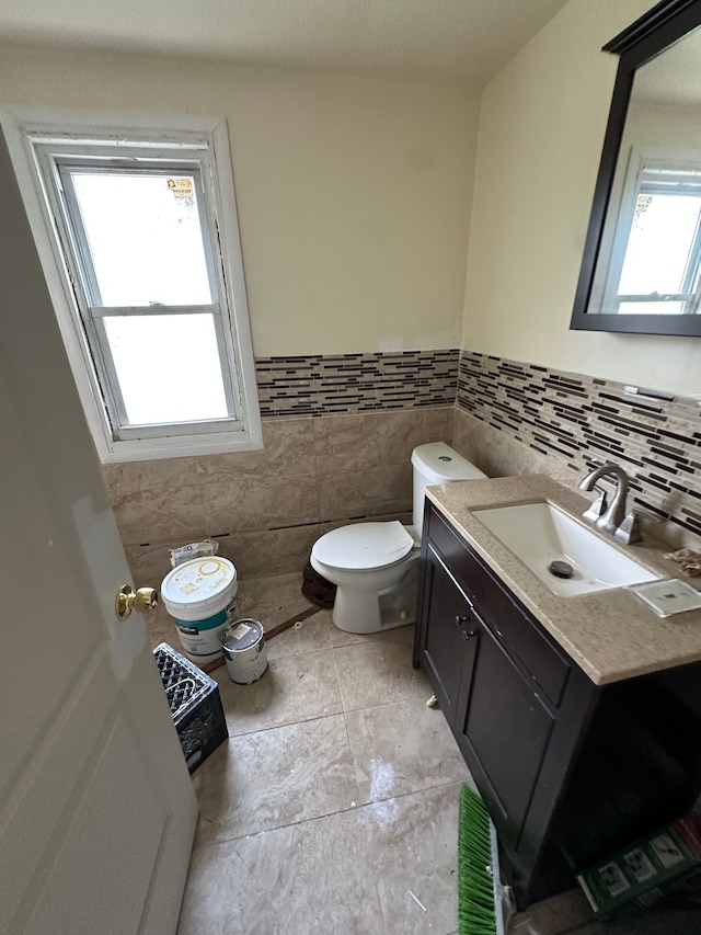 9982 Littlefield St, Detroit, MI 48227 - half bathroom featuring toilet, vanity, a wainscoted wall, and tile walls
