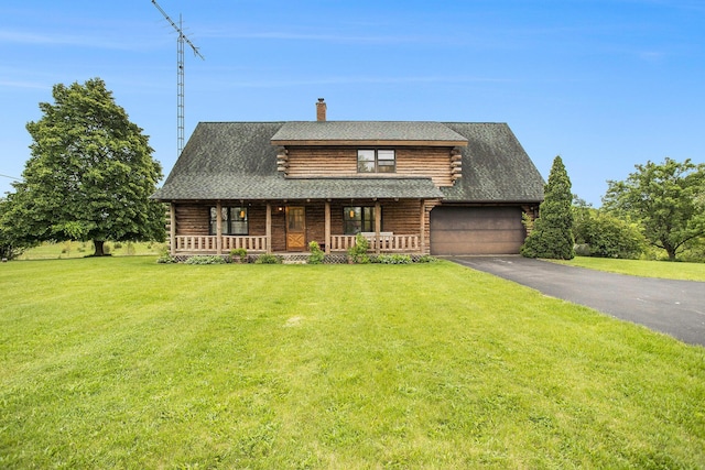 log home with log exterior, a chimney, a front yard, and driveway