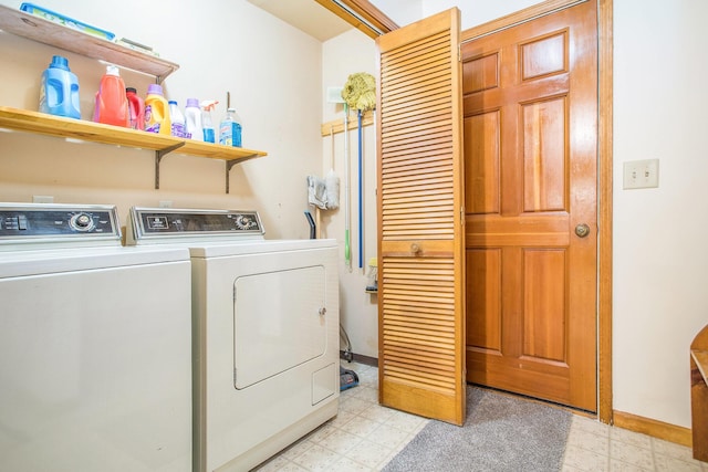 laundry room with light floors, washing machine and dryer, and baseboards