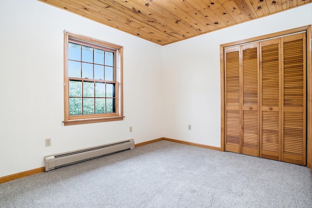 unfurnished bedroom with a baseboard heating unit, carpet floors, wood ceiling, baseboards, and a closet