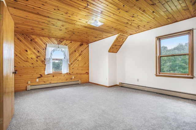 additional living space with a baseboard heating unit, carpet flooring, wood walls, baseboards, and wooden ceiling
