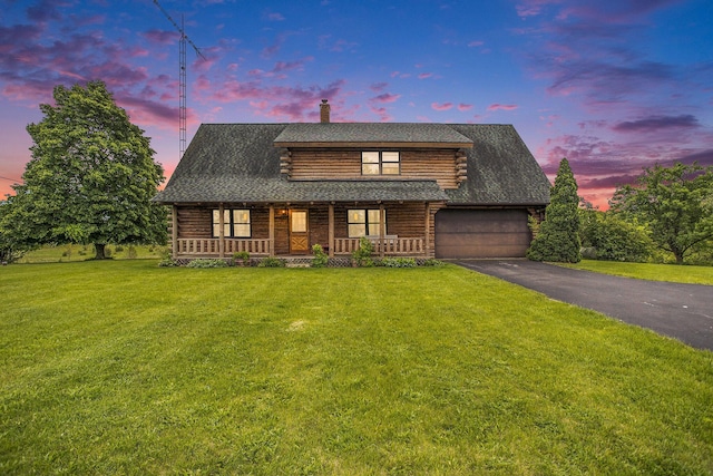 log home featuring log exterior, driveway, a garage, covered porch, and a lawn