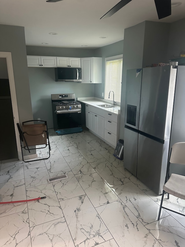 17532 Russell St, Highland Park, MI 48203 - kitchen with appliances with stainless steel finishes, a sink, white cabinetry, and light marble finish floors
