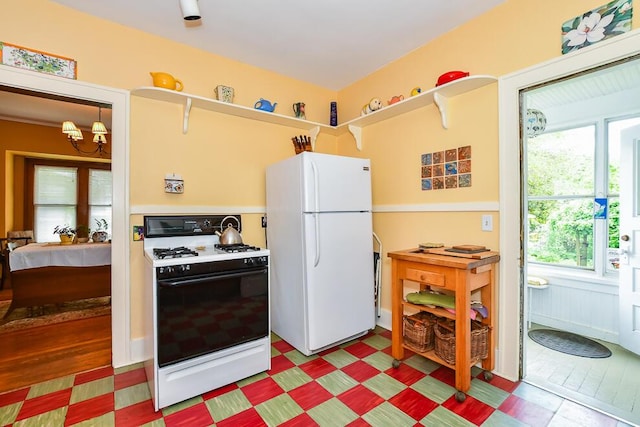 kitchen featuring white appliances and a chandelier