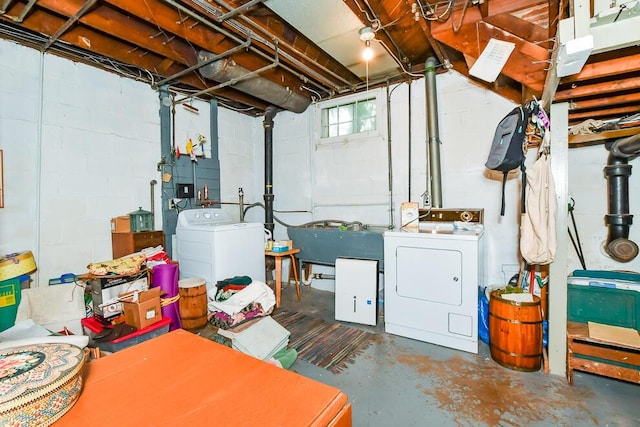 below grade area with separate washer and dryer, concrete block wall, and a sink