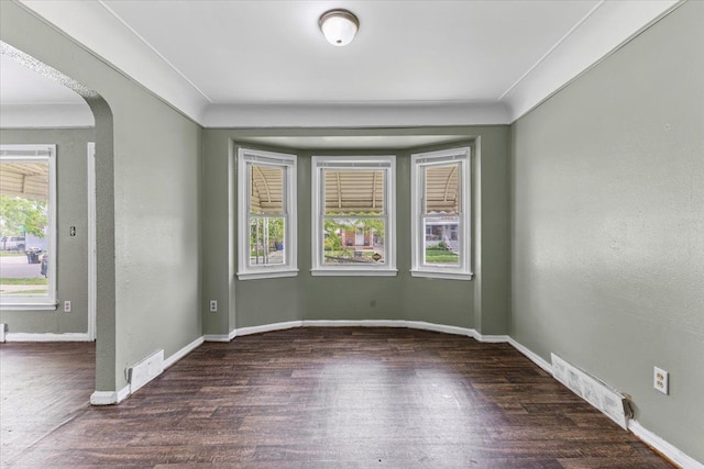 6905 Archdale St, Detroit, MI 48228 - empty room with wood finished floors, baseboards, arched walkways, and a textured wall