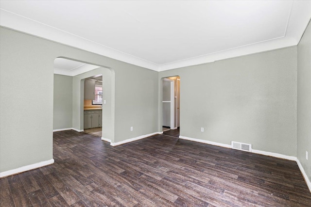 6905 Archdale St, Detroit, MI 48228 - spare room with arched walkways, dark wood finished floors, baseboards, and crown molding