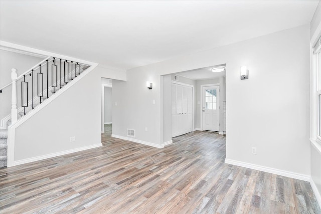 15016 Sunbury St, Livonia, MI 48154 - unfurnished living room featuring stairs, wood finished floors, and baseboards