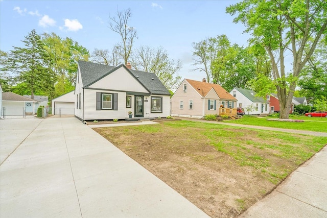 15016 Sunbury St, Livonia, MI 48154 - view of front of home with a detached garage, roof with shingles, a front lawn, and an outdoor structure