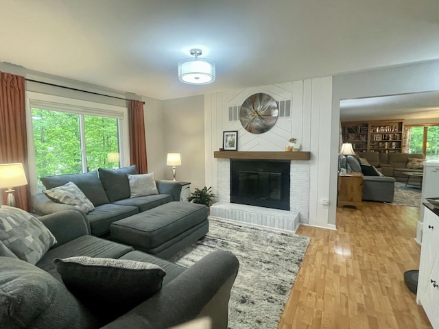 19490 Island Lake Rd, Chelsea, MI 48118 - living room with a brick fireplace and light wood-style flooring