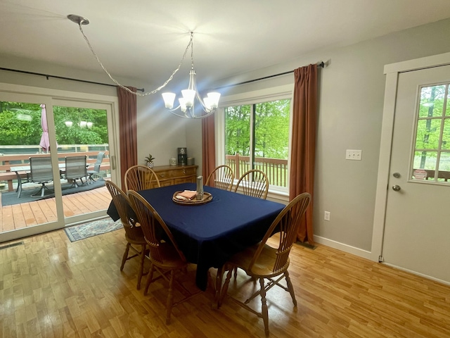 19490 Island Lake Rd, Chelsea, MI 48118 - dining space featuring a chandelier, light wood-type flooring, and baseboards