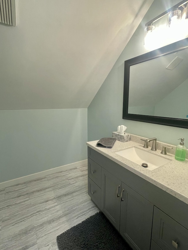 19490 Island Lake Rd, Chelsea, MI 48118 - bathroom with lofted ceiling, vanity, wood finished floors, and baseboards
