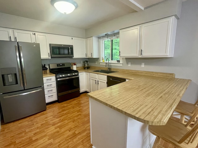 19490 Island Lake Rd, Chelsea, MI 48118 - kitchen featuring appliances with stainless steel finishes, a sink, a peninsula, and white cabinets