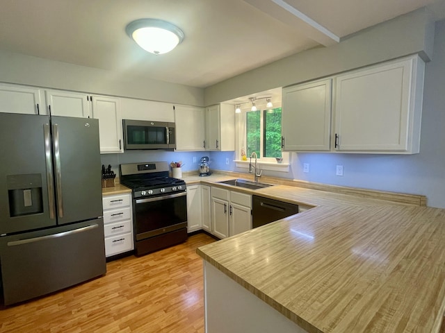 19490 Island Lake Rd, Chelsea, MI 48118 - kitchen with appliances with stainless steel finishes, a sink, light countertops, a peninsula, and white cabinets
