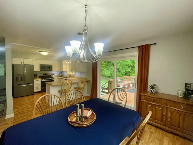 19490 Island Lake Rd, Chelsea, MI 48118 - dining room with a chandelier and light wood-type flooring