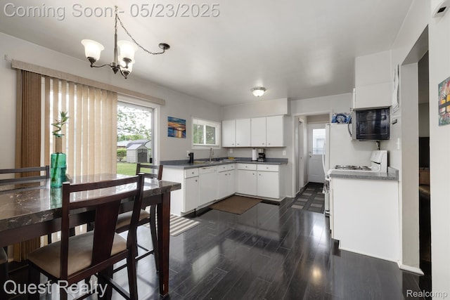 3680 Shoals St, Waterford, MI 48329 - kitchen featuring black microwave, white dishwasher, a chandelier, white cabinets, and a sink