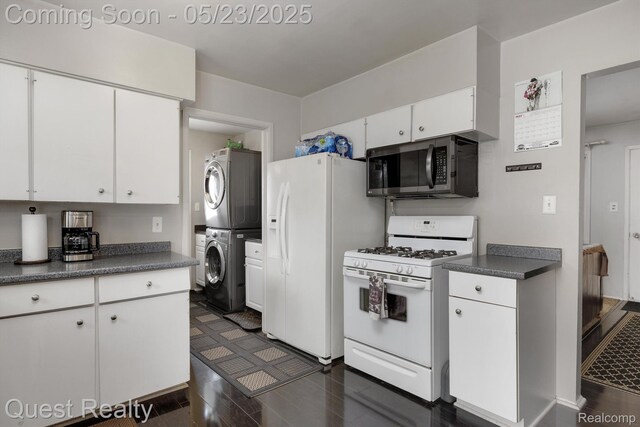 3680 Shoals St, Waterford, MI 48329 - kitchen with white appliances, stacked washer / dryer, dark countertops, dark wood-style flooring, and white cabinets