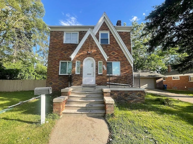 8056 Fisher Ave, Warren, MI 48089 - tudor house with brick siding, a chimney, and a garage