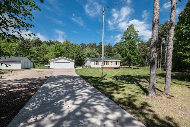 4171 E 124th St, Grant, MI 49327 - view of front of house with a detached garage, a front lawn, and a wooded view