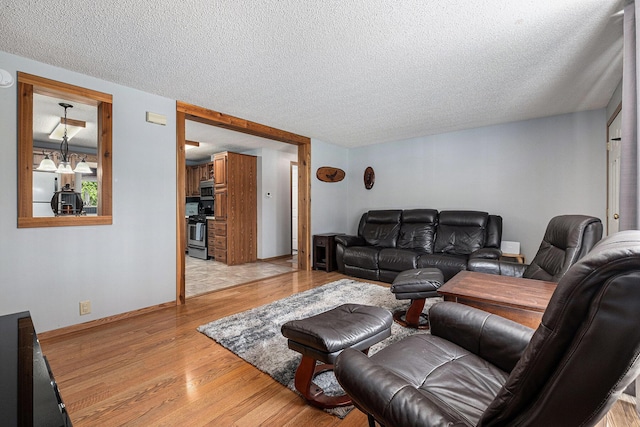 4171 E 124th St, Grant, MI 49327 - living room featuring light wood-style floors and a textured ceiling