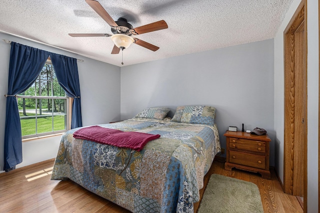 4171 E 124th St, Grant, MI 49327 - bedroom featuring wood finished floors, a textured ceiling, baseboards, and a ceiling fan