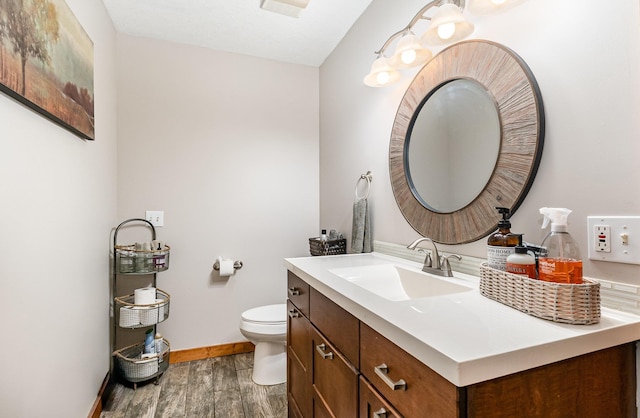 5511 Westside Dr, Alger, MI 48610 - half bathroom featuring baseboards, wood finished floors, toilet, and vanity
