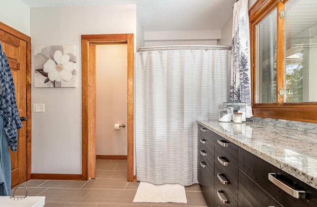 5511 Westside Dr, Alger, MI 48610 - bathroom with vanity, tile patterned floors, baseboards, a shower with curtain, and a textured ceiling