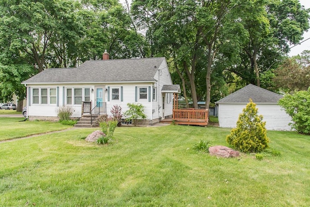 view of front of home with a chimney, a front lawn, a shingled roof, and a wooden deck